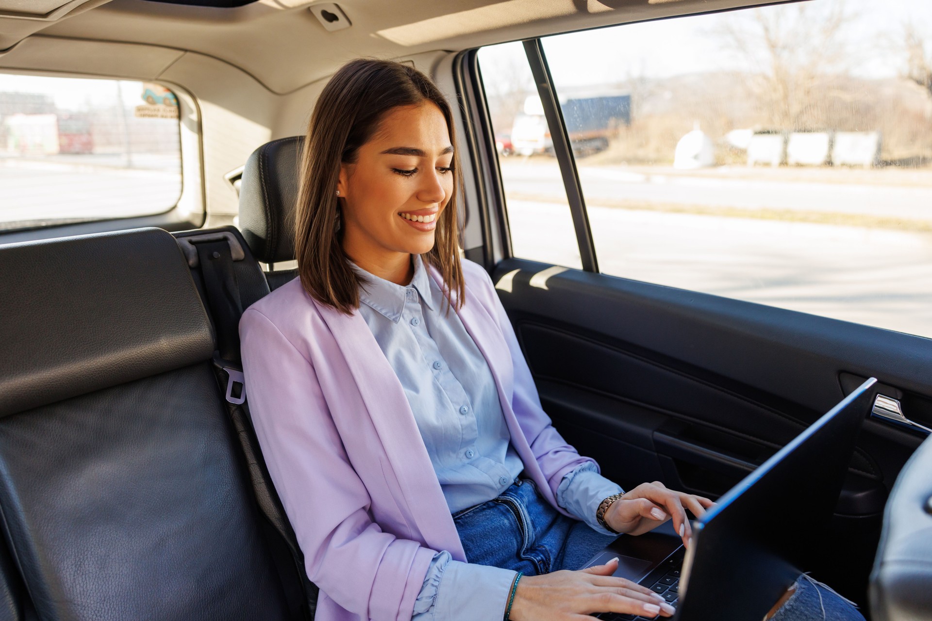 Businesswoman working on laptop during car ride in the city